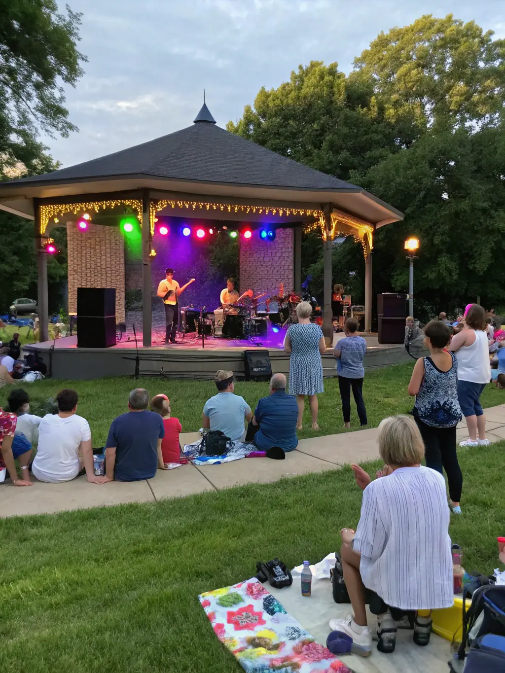 An engaging image of a live outdoor concert organized by SYLVAIN PICOT MUSIQUE, with families and children enjoying music in a public square, reflecting cultural access for all.